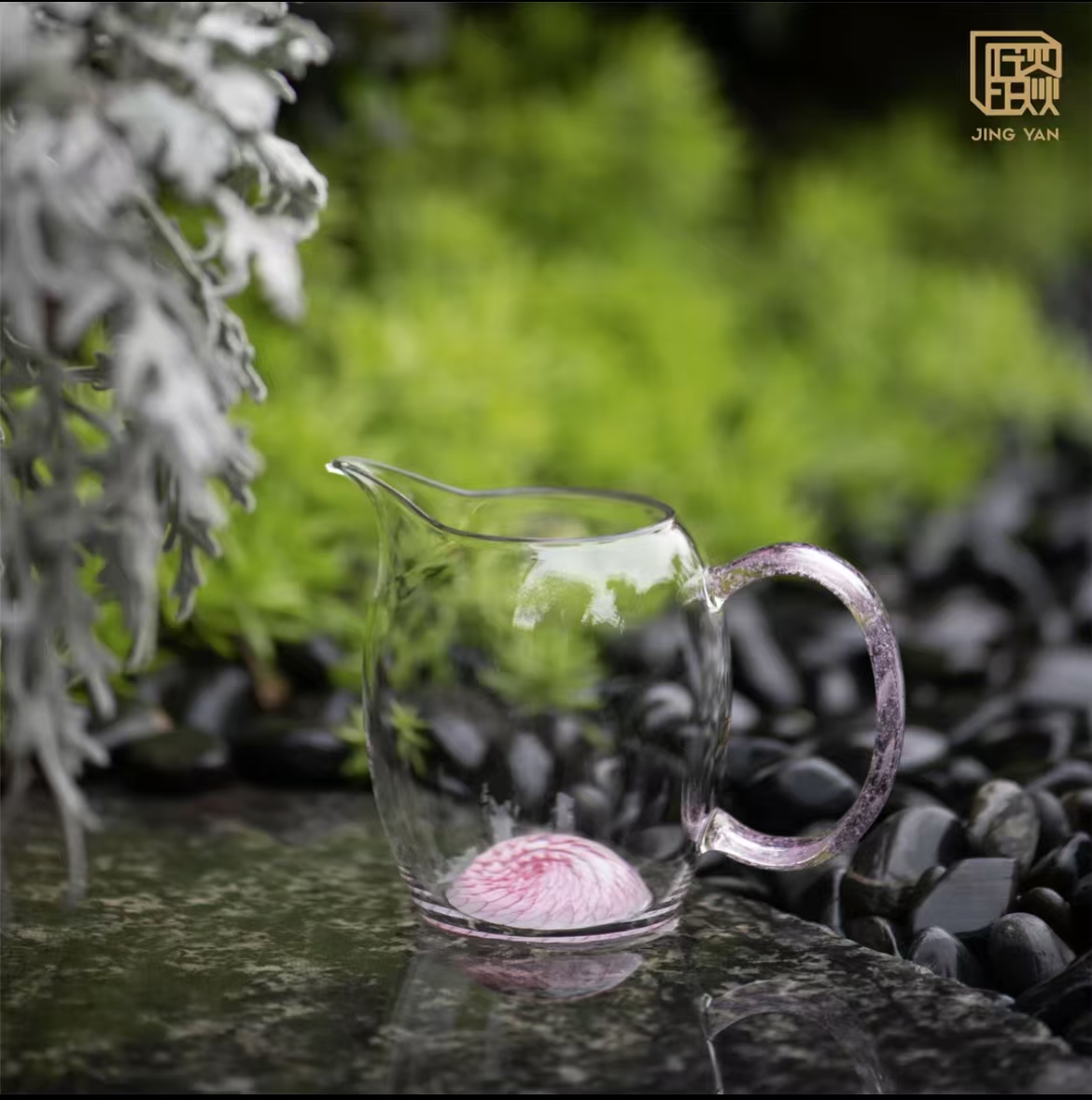 Glass tea server with pink handle and flower design in base