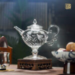 Round bottom glass teapot with textured body and cloud handle